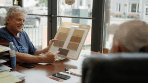 Homeowner comparing hardwood flooring samples during a consultation in Marcellus