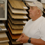 Explaining hardwood flooring options in front of the showroom sample wall